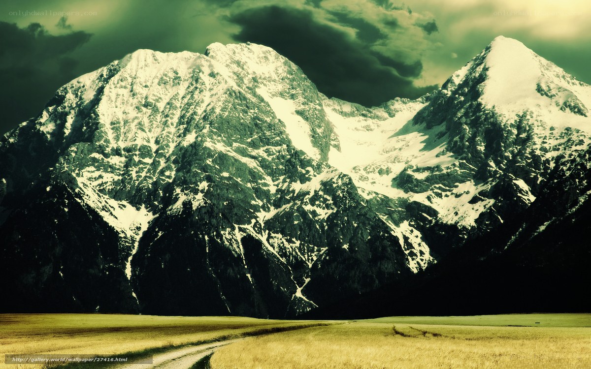Snow-capped mountains under stormy sky