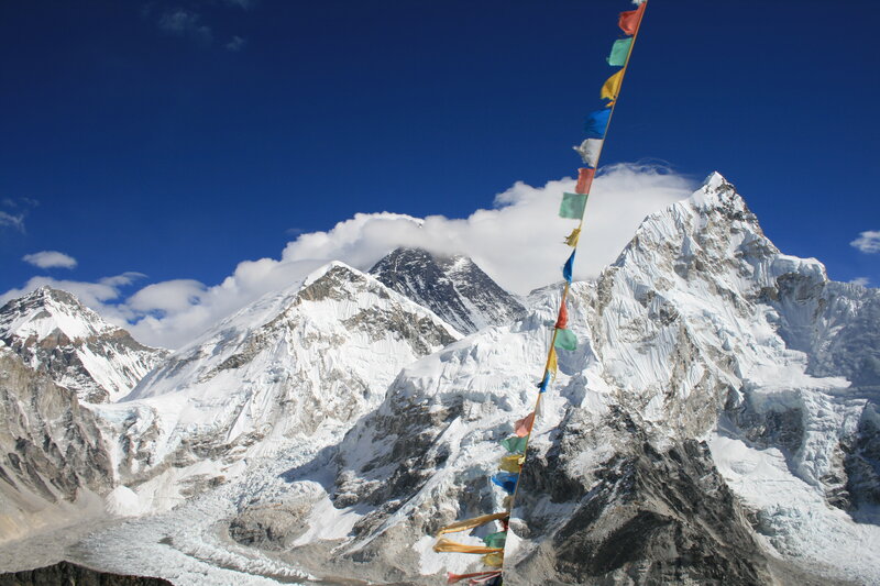 snow-capped mountains with prayer flags