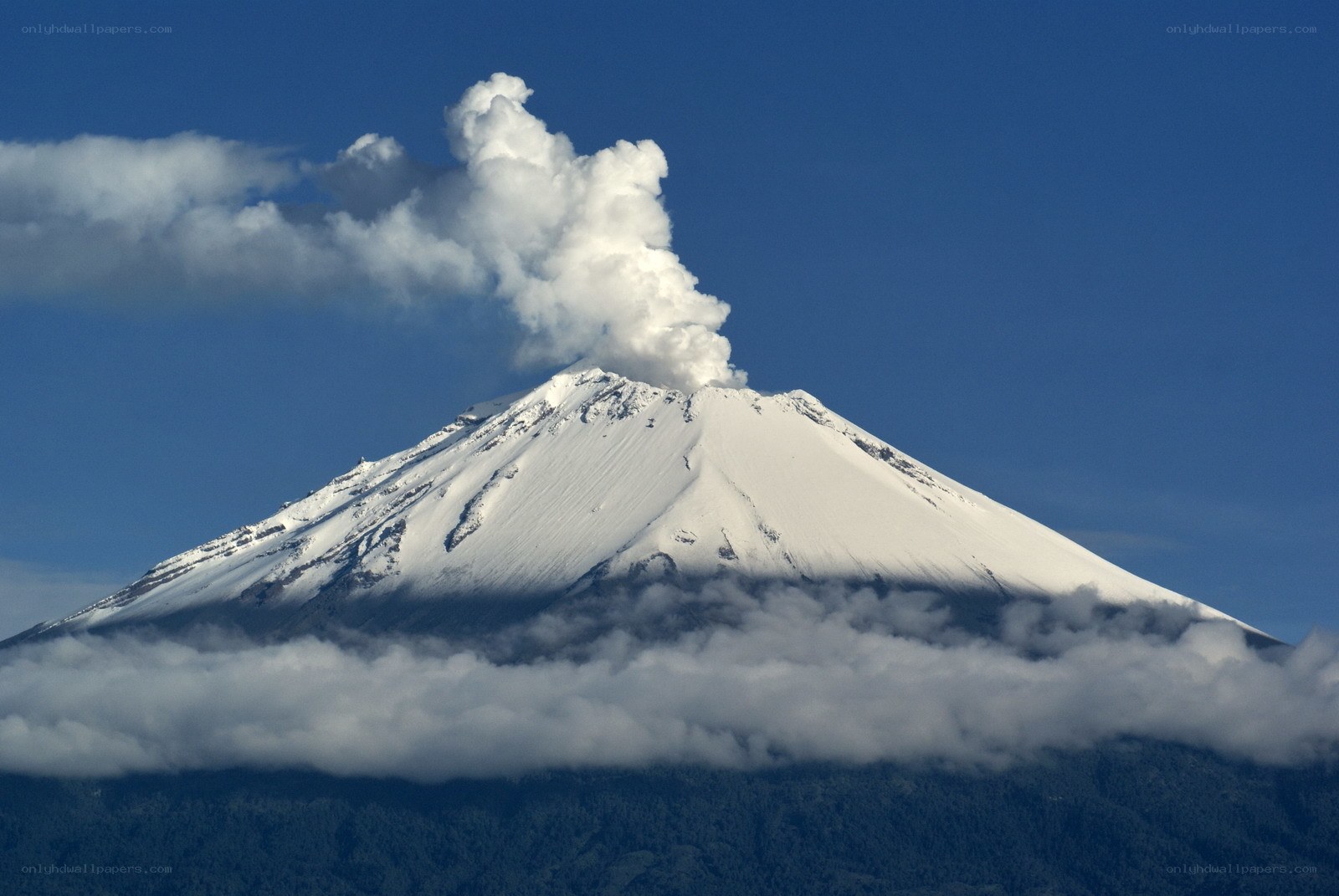 Snow-capped volcano erupting