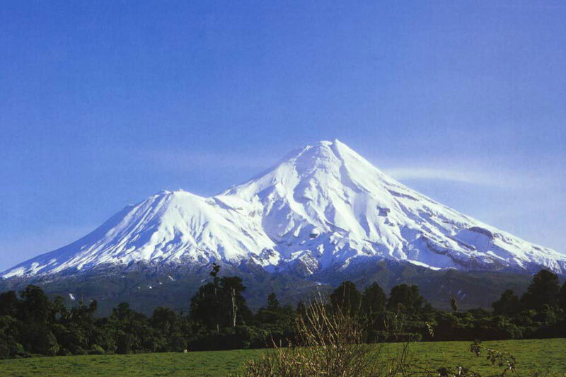 Snow-capped volcano in a green landscape