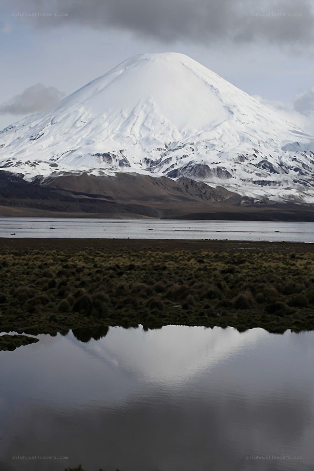 Snow-capped volcano reflected in lake
