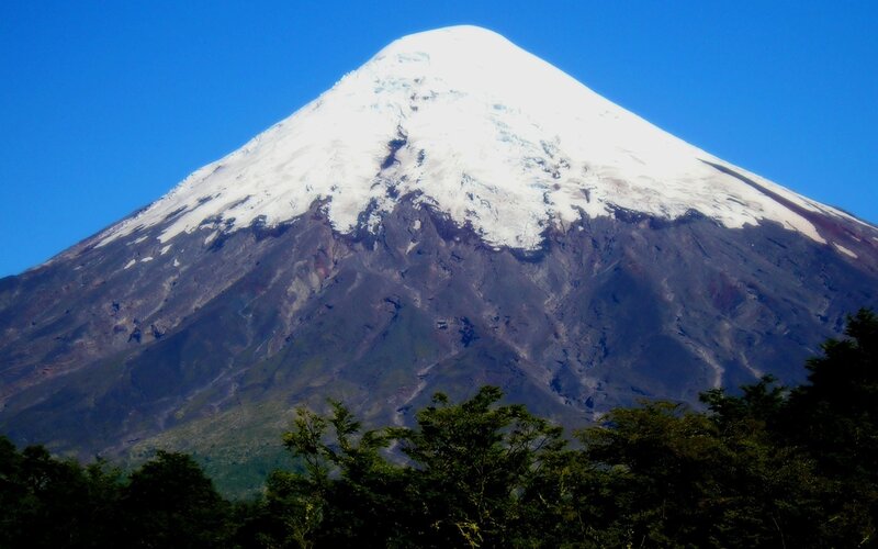 Snow-capped volcano under blue sky