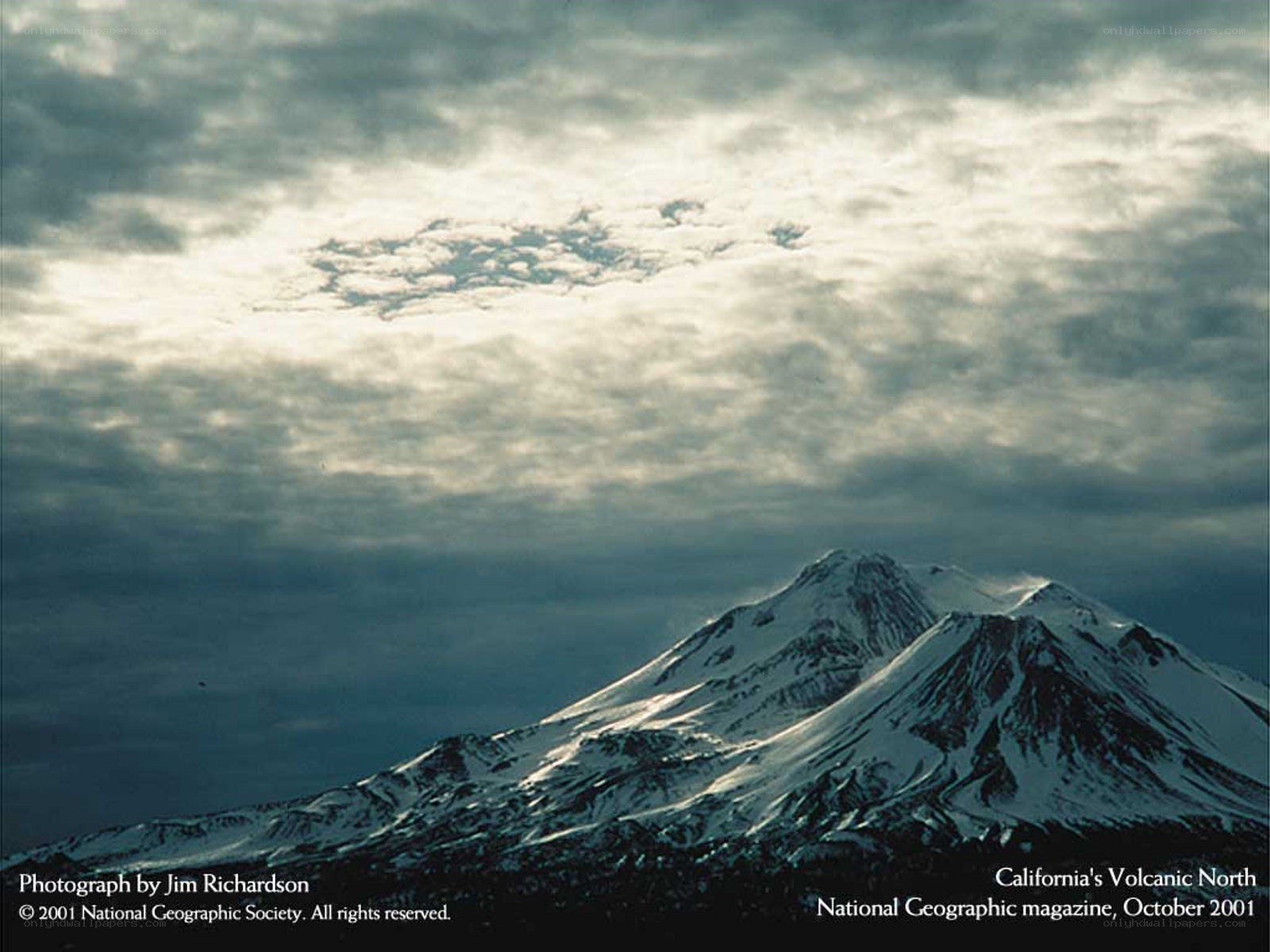 Snow-Capped Volcano Under Clouds