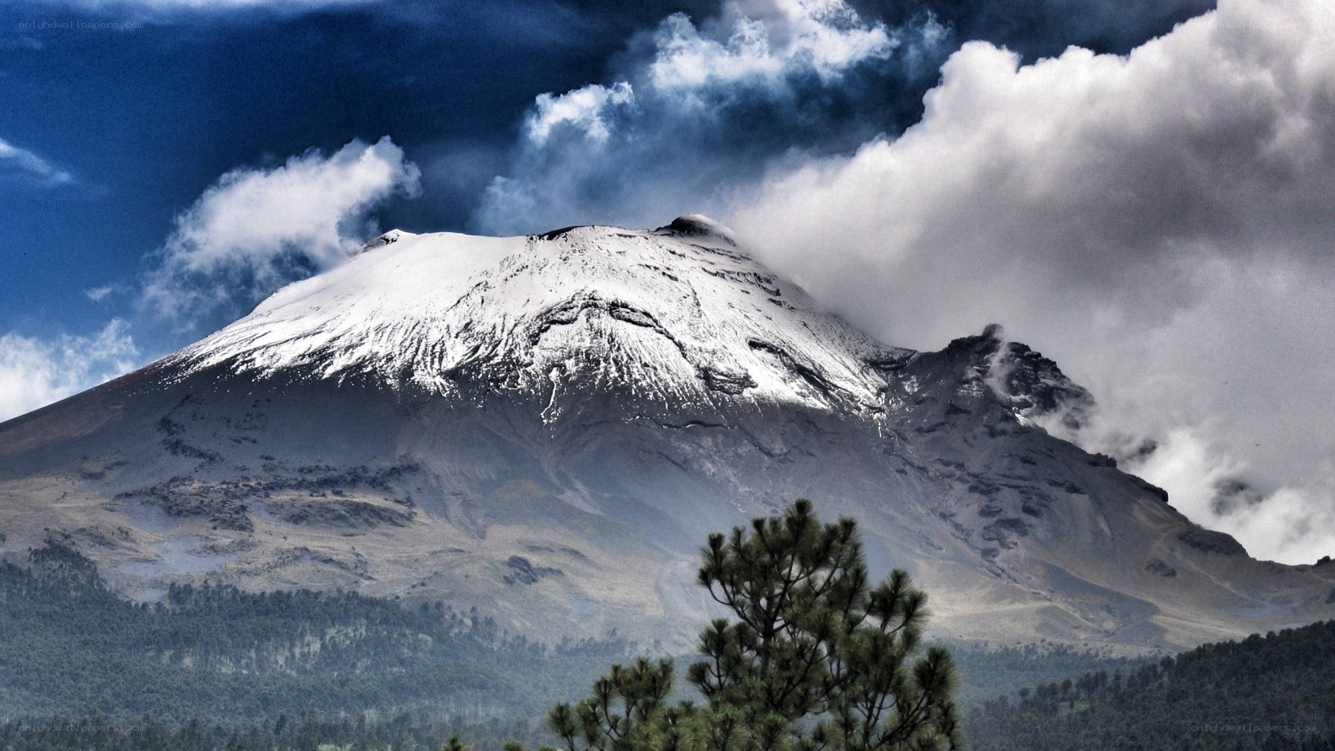 Snow-capped volcano under stormy sky
