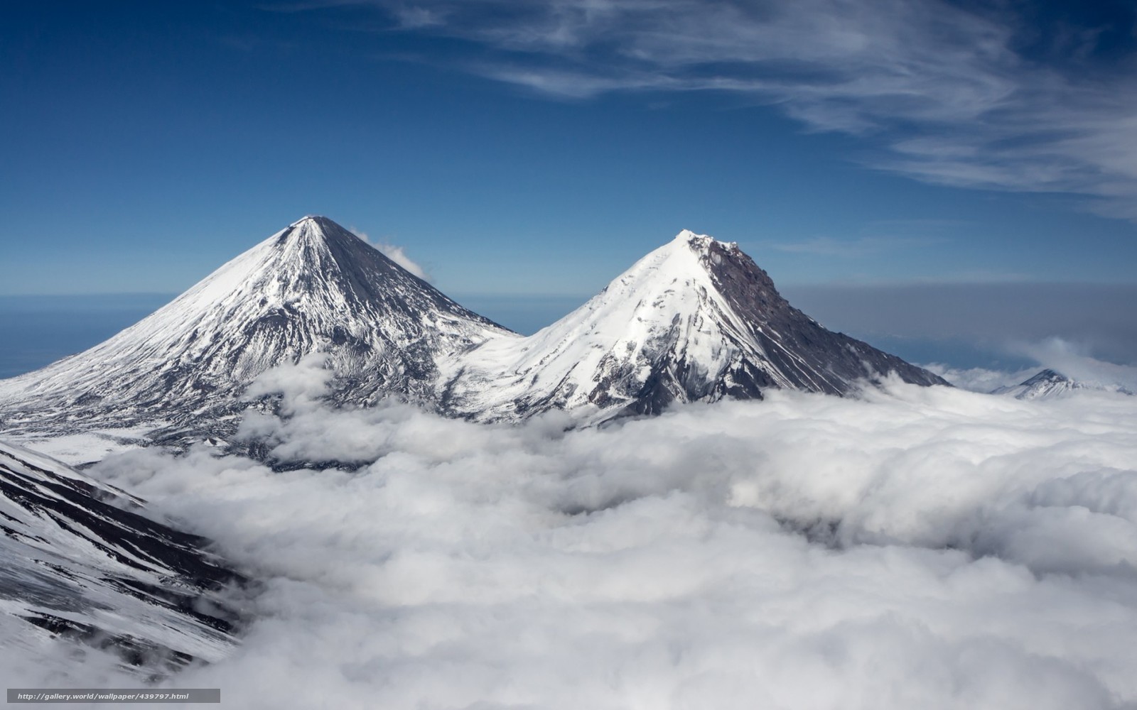 Snow-capped volcanoes above clouds