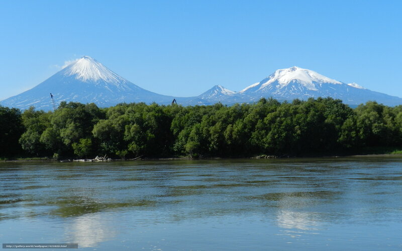 Snow-capped volcanoes by a river