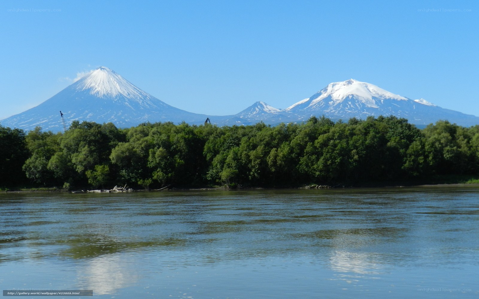 Snow-capped volcanoes by a river