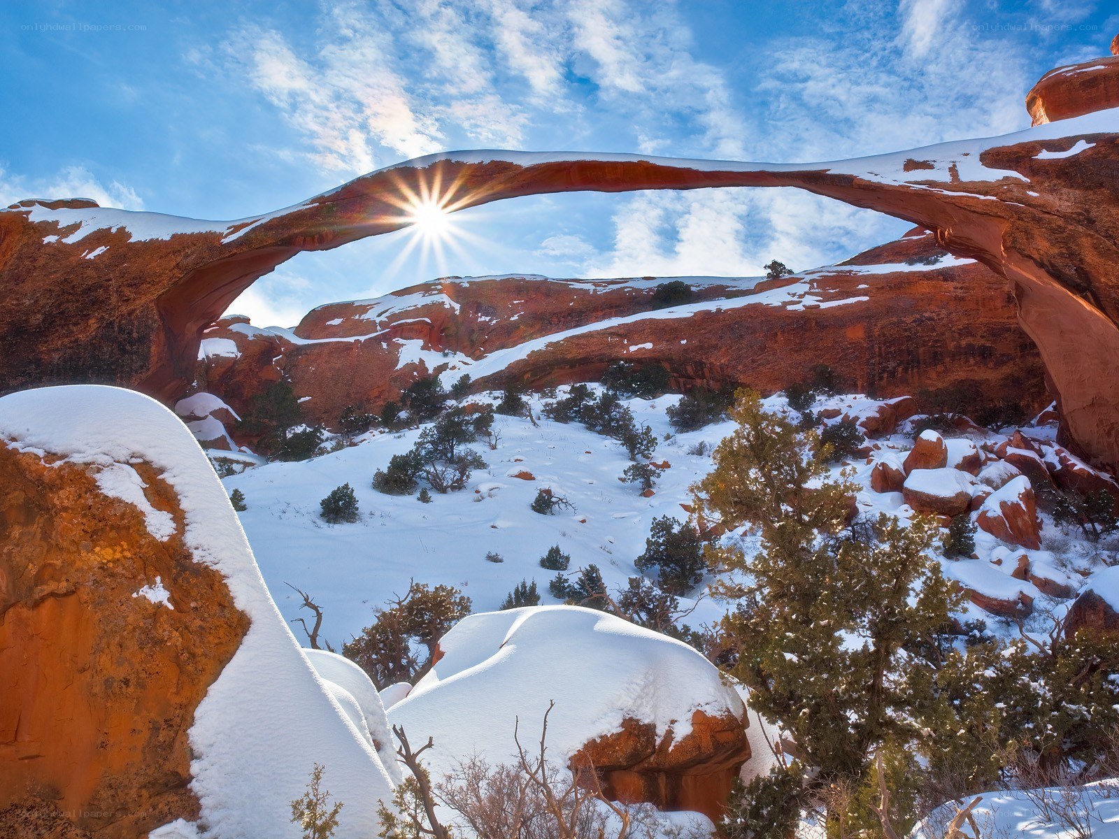 Snow-covered arch with sunburst