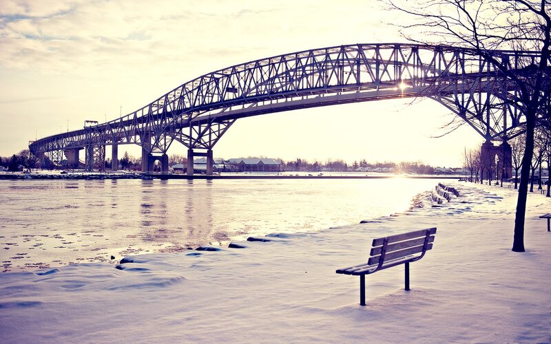 Snow-covered Bench by Bridge — White, Serene, Winter