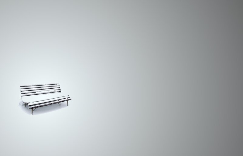 Snow-covered bench in winter