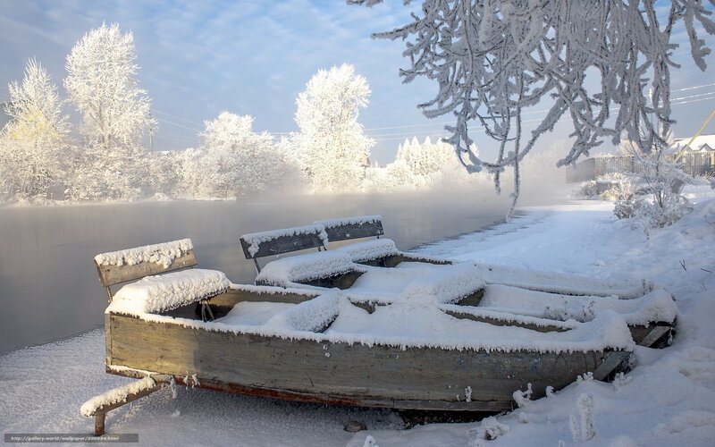 Snow-covered boat on a frozen river