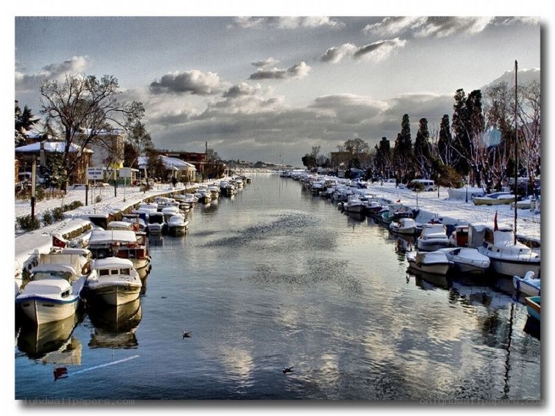 snow-covered boats in canal