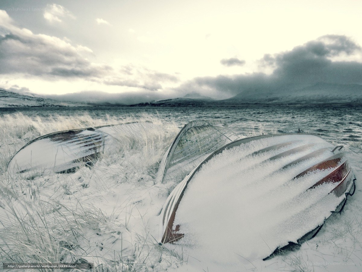 Snow-covered boats on a beach