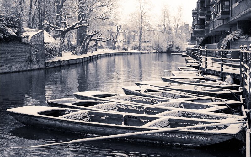 Snow-covered boats on a river