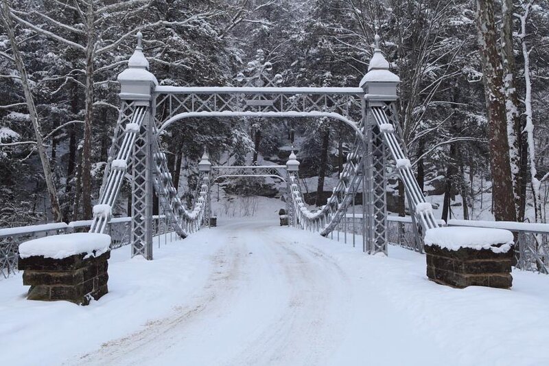 Snow-covered bridge in winter forest