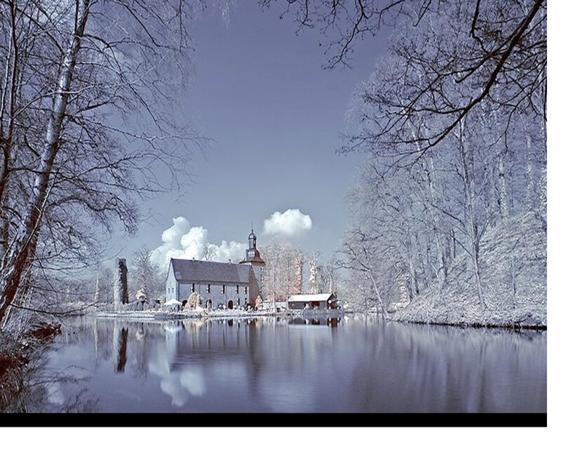 Snow-covered Building by Lake
