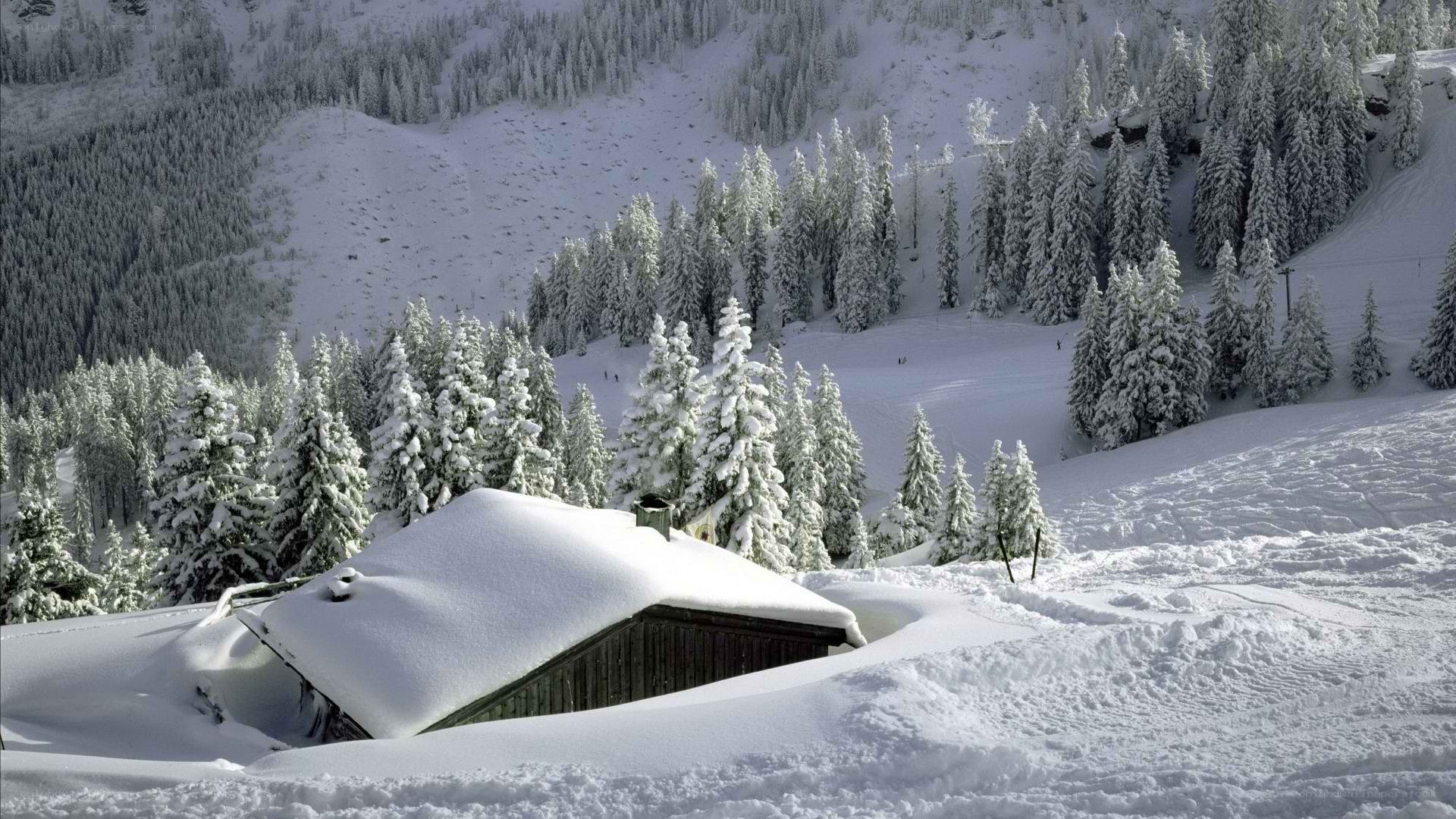 Snow-covered cabin in mountain valley