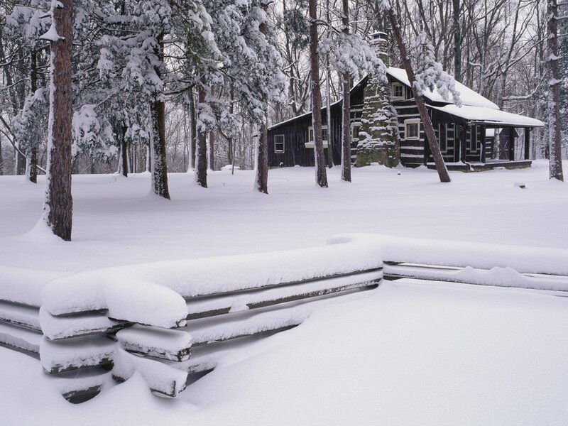 Snow-covered cabin in winter forest