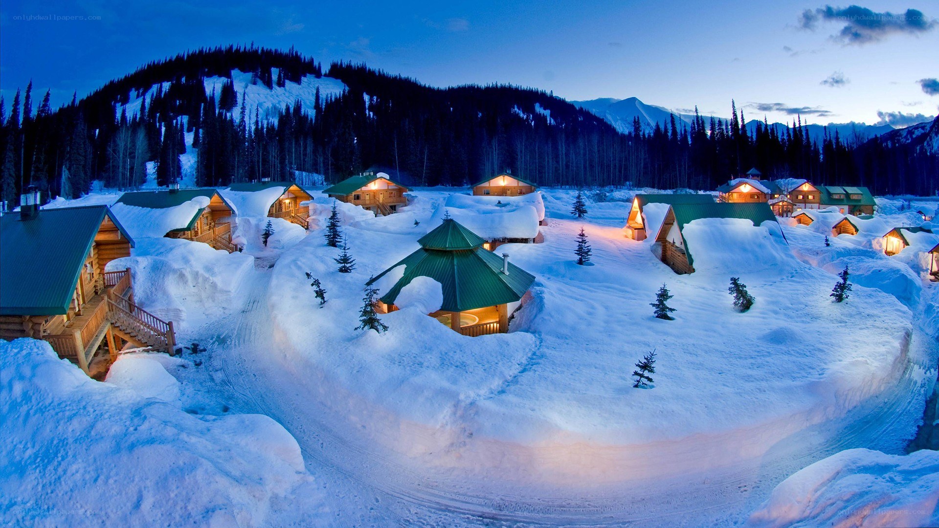 Snow-covered cabins at dusk