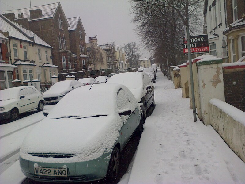 Snow-covered Cars on Street