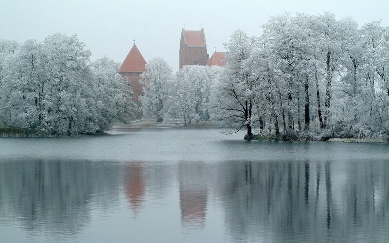 Snow-covered castle by a lake