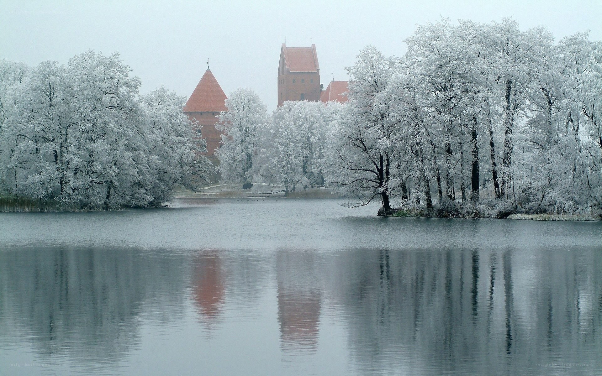 Snow-covered castle by a lake