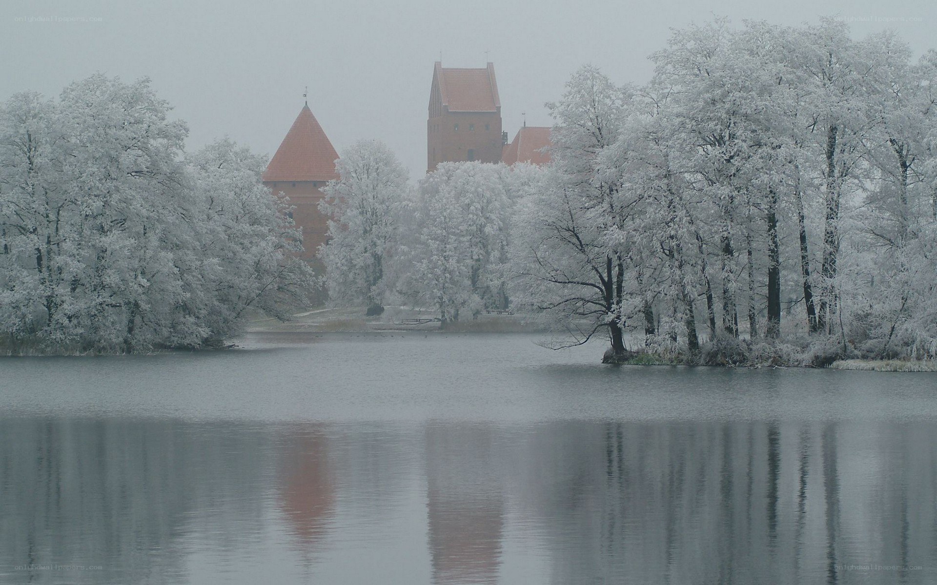 Snow-covered castle by a lake