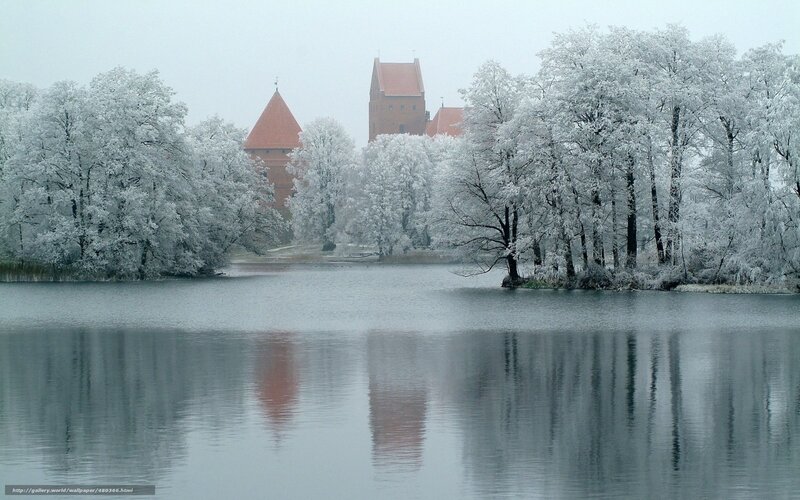 Snow-covered castle by lake