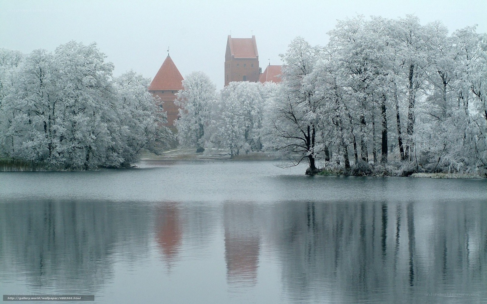 Snow-covered castle by lake
