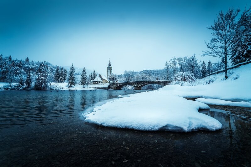 Snow-covered Church by River