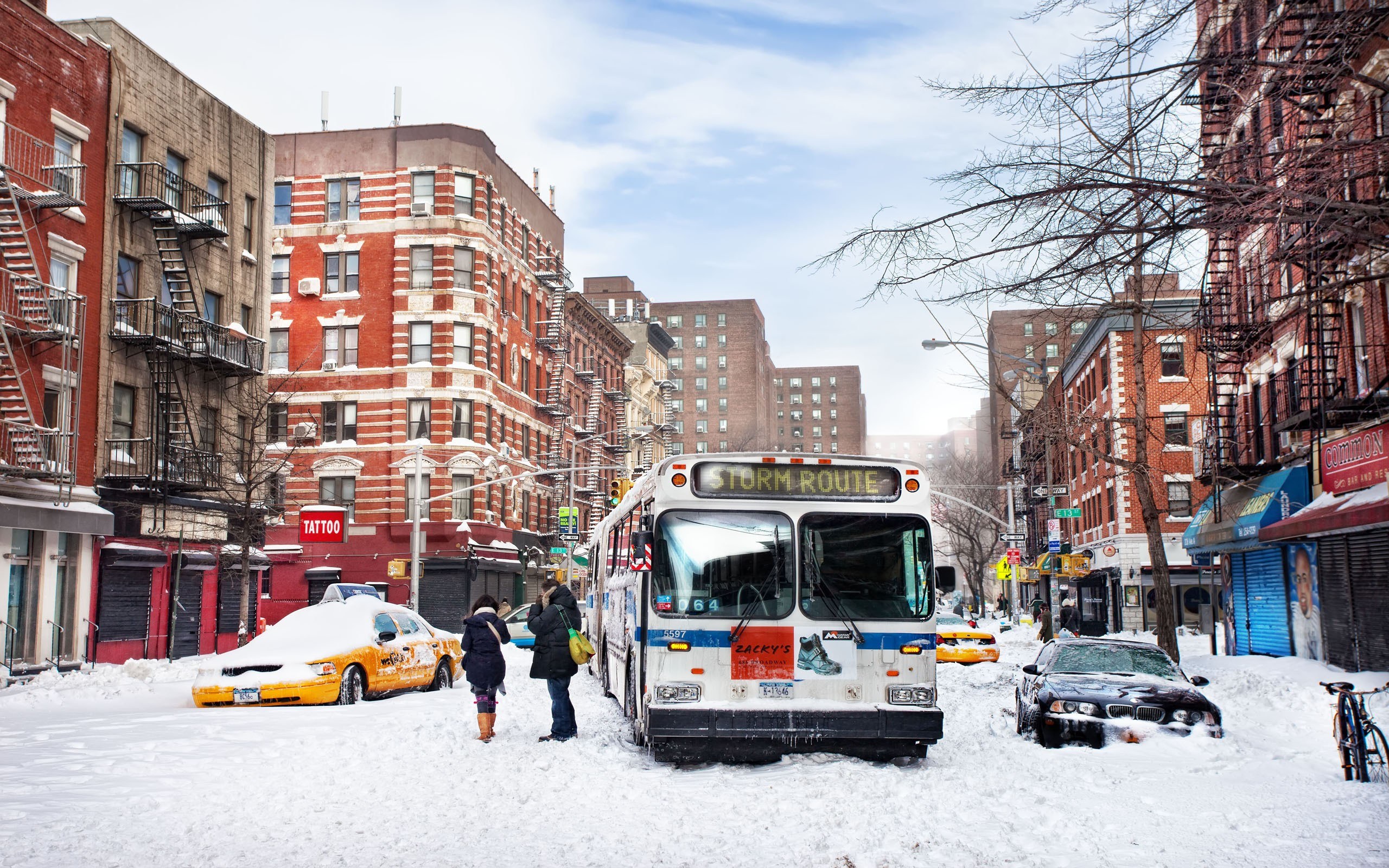 Snow-covered city street with bus