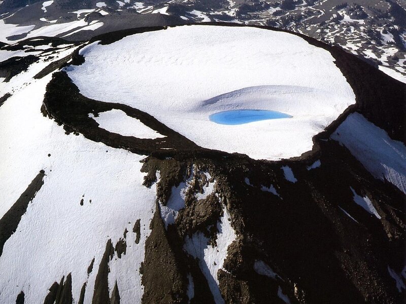 snow-covered crater with blue lake
