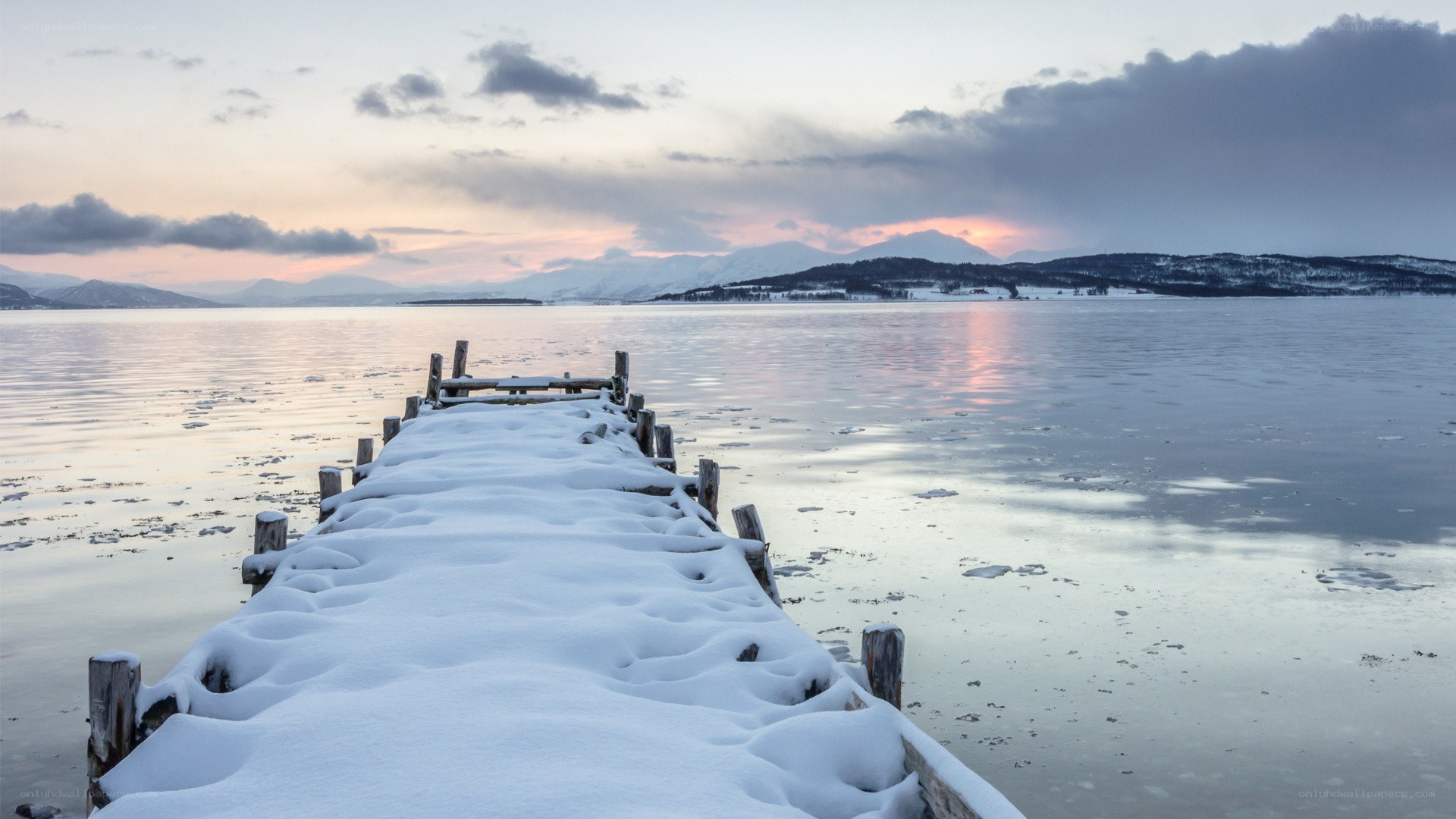 Snow-covered dock at sunset