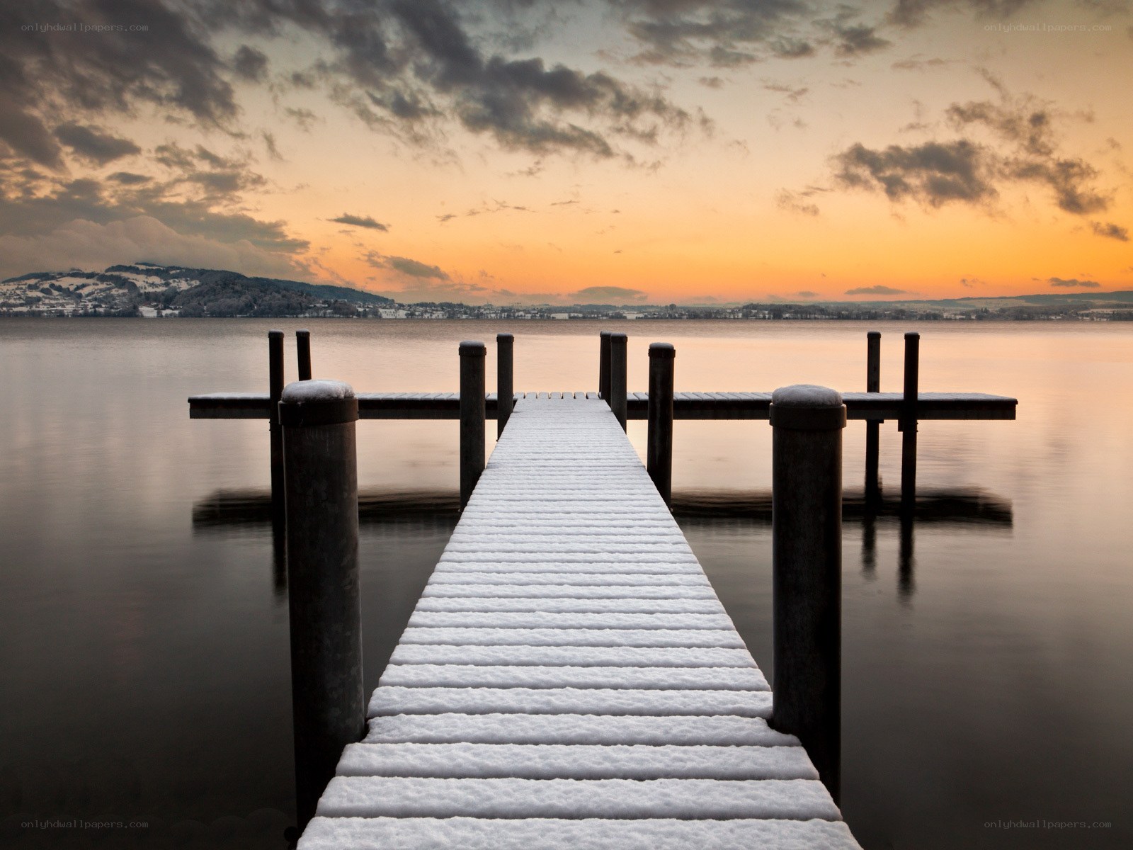 Snow-covered dock at sunset