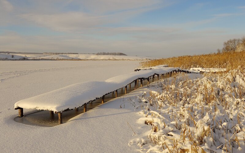 Snow-covered dock on frozen lake
