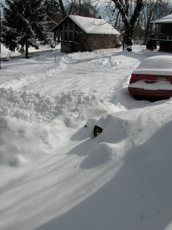 Snow-covered driveway and cabin