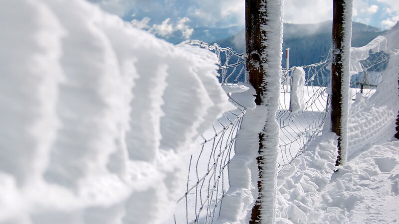 snow-covered fence in mountains