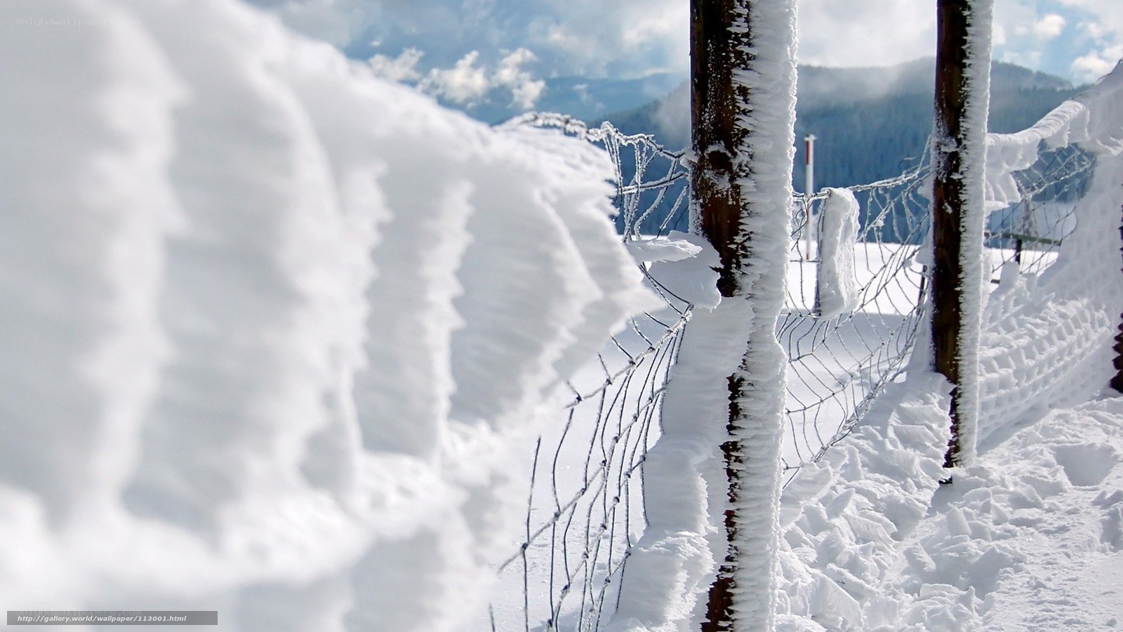 Snow-covered fence in mountains