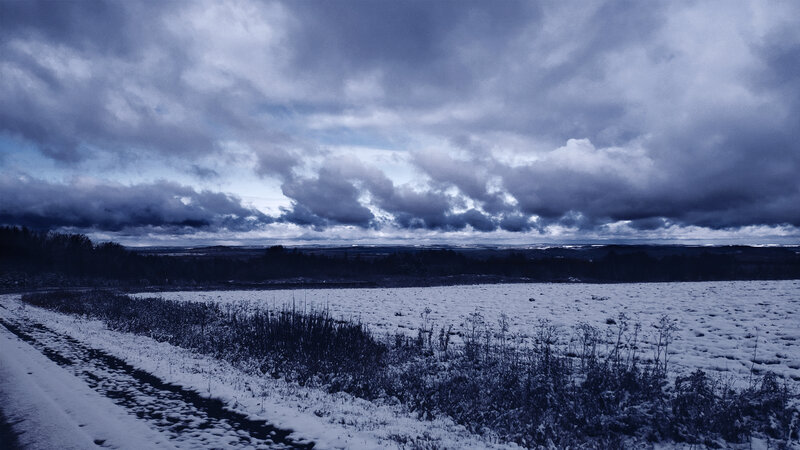 Snow-covered Field under Clouds