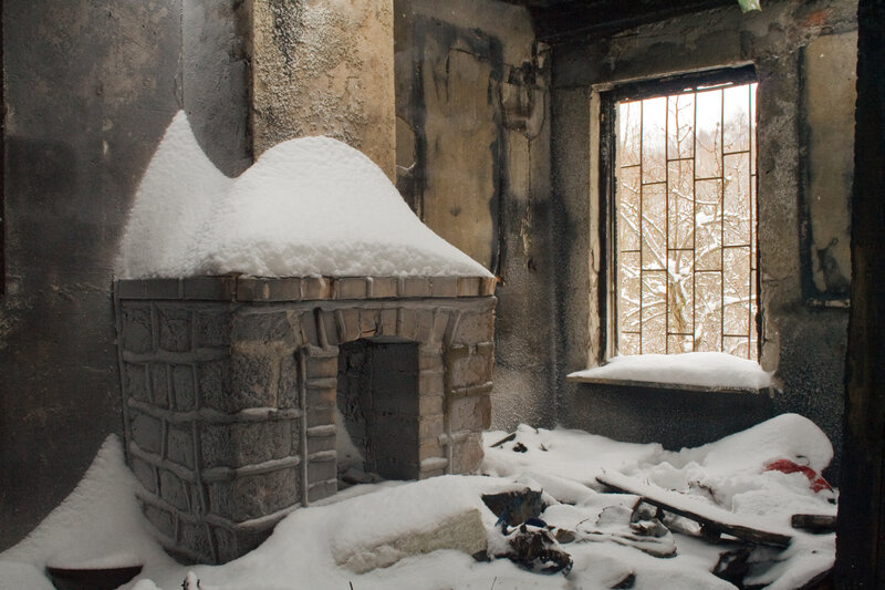 Snow-covered fireplace in a burned-out room