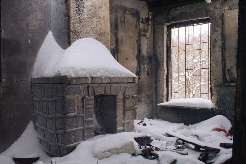 Snow-covered fireplace in a burned-out room