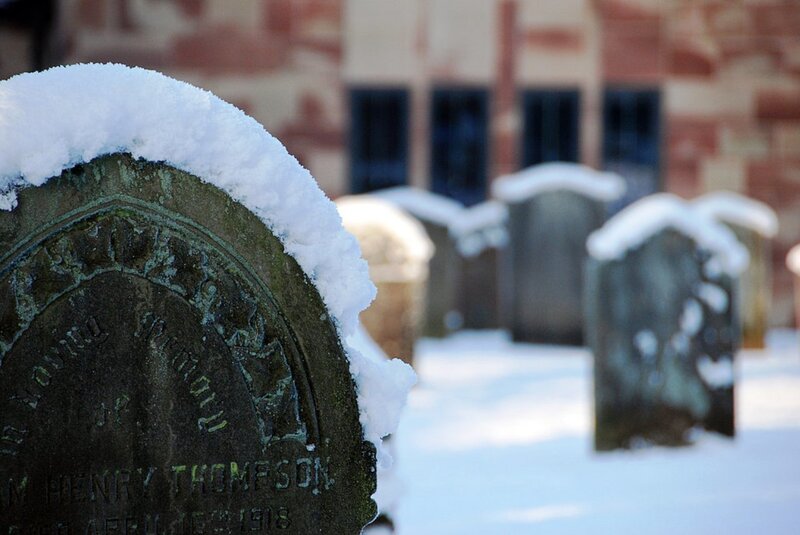 Snow-covered gravestones in a cemetery
