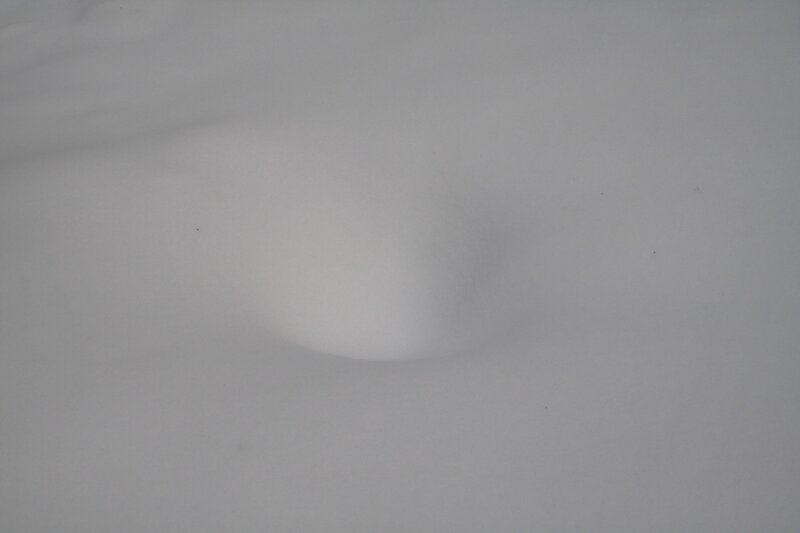 snow-covered ground with depression