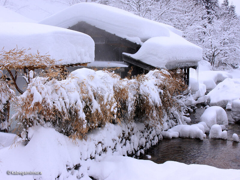 Snow-covered house by a stream