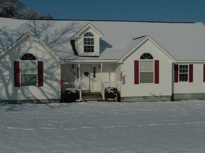 snow-covered house with red shutters