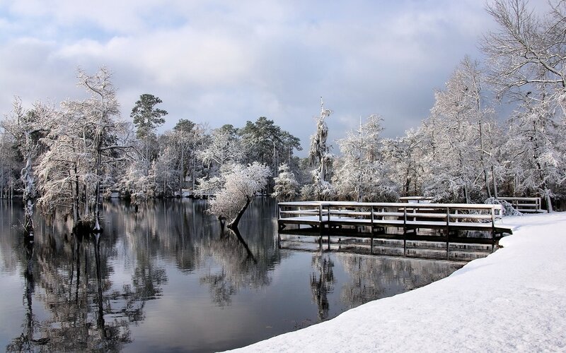 Snow-covered lake with wooden bridge