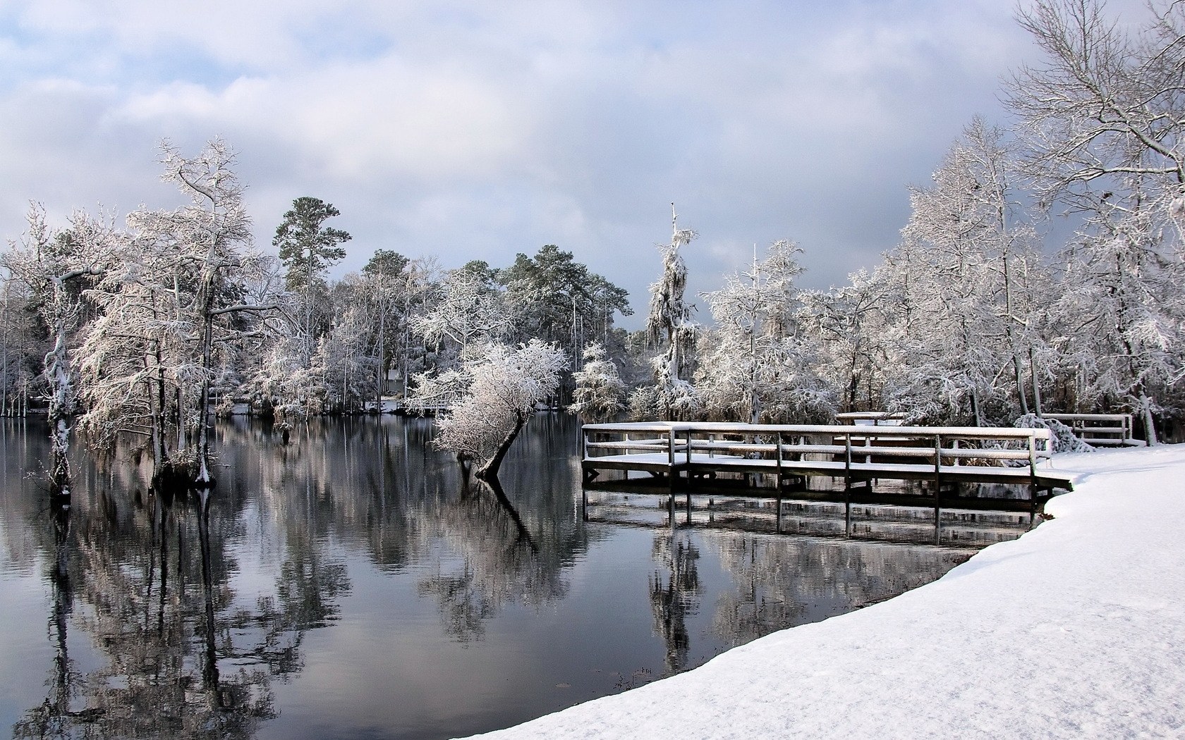 Snow-covered lake with wooden bridge