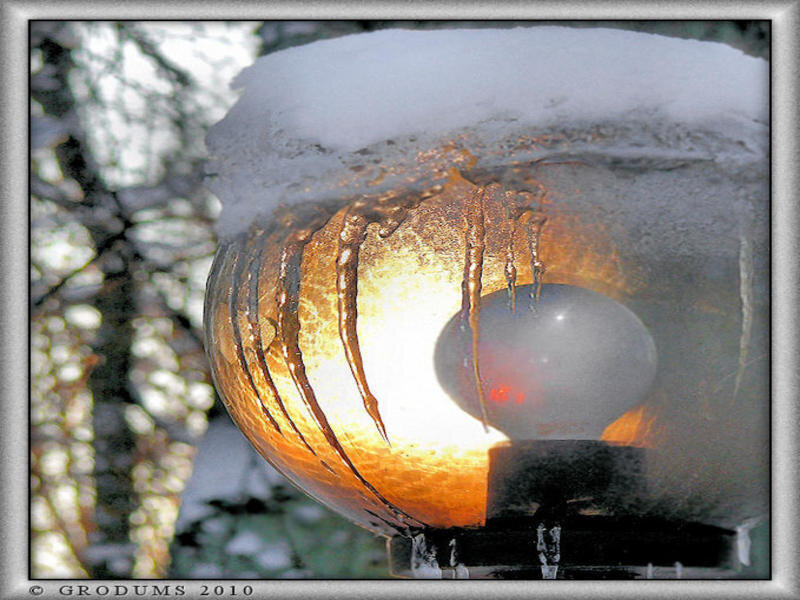 Snow-covered lamp with icicles