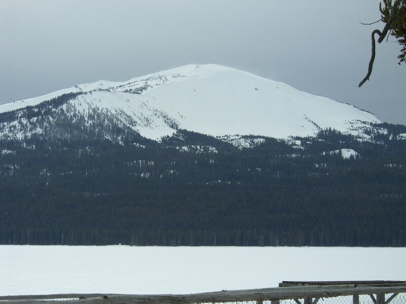 snow-covered mountain by frozen lake