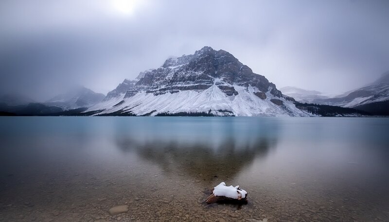 Snow-covered Mountain Lake — Blue, Serene, Winter, Photograph, Driftwood